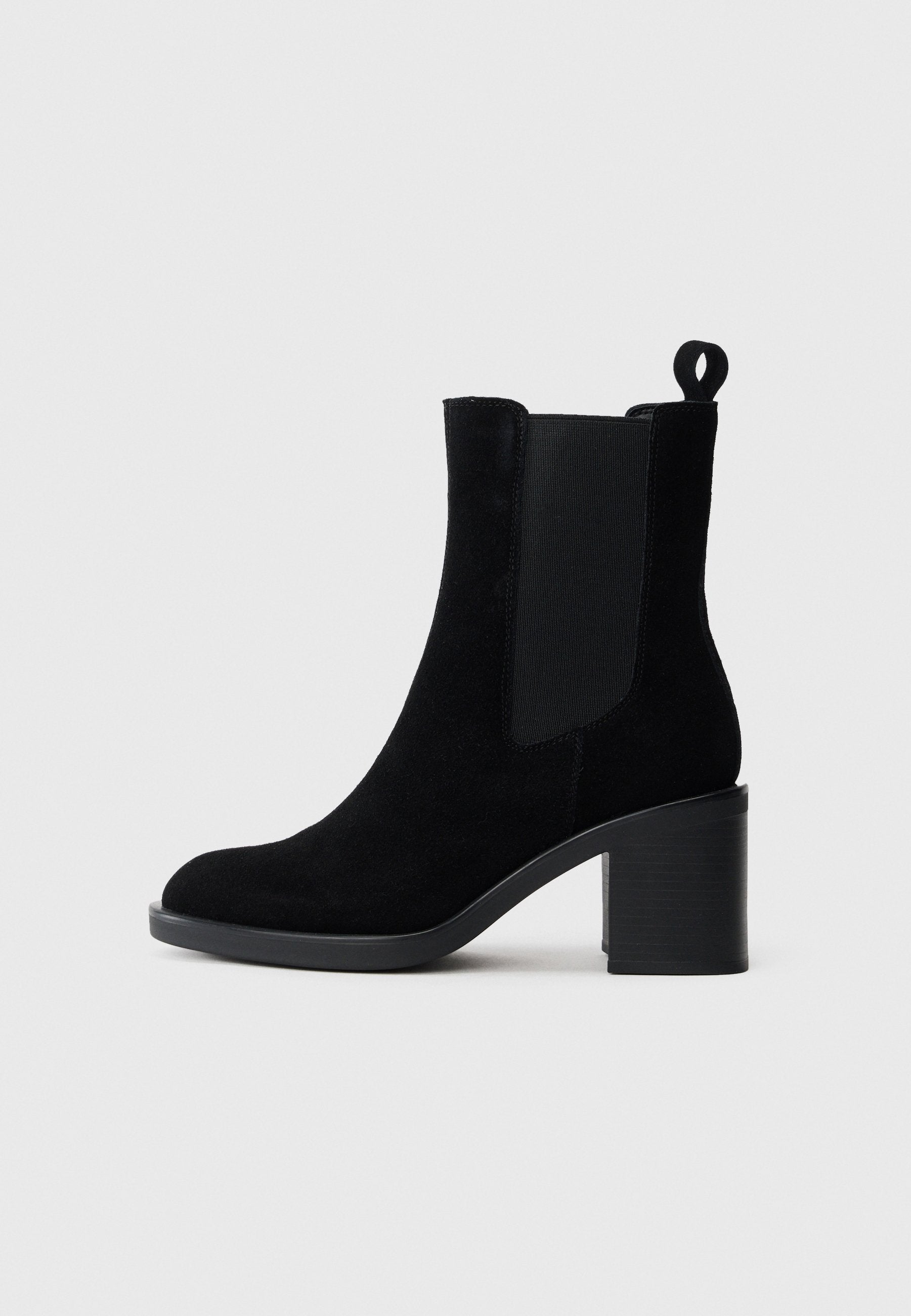 Schwarze Wildleder-Ankle-Boots mit Blockabsatz, elastischen Seitenteilen und einem Zugband an der Rückseite. Glatte Textur und abgerundete Zehenform.