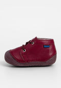 Burgunderfarbene Lederschuhe für Kinder mit braunen Gummisohlen, runder Spitze und Schnürdesign. Mit einem kleinen blauen "Richter"-Logo.