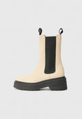 Beige Knöchelstiefel mit schwarzem elastischem Seitenteil und Gummisohle, ausgestattet mit einem auffälligen Markenlogo an der Ferse. Einfaches, modernes Design.