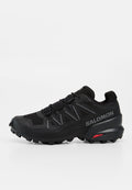 Schwarzer Salomon Trailrunning-Schuh mit aggressivem Profil, reflektierenden Details und Contagrip-Sohle für optimalen Grip im Gelände.