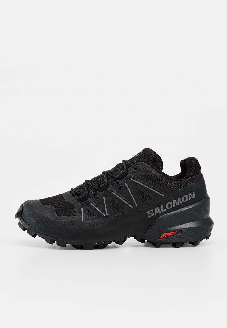 Schwarzer Salomon Trailrunning-Schuh mit aggressivem Profil, reflektierenden Details und Contagrip-Sohle für optimalen Grip im Gelände.