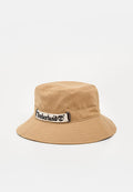 Hellbrauner Baumwoll-Bucket-Hut mit breiter Krempe und aufgenähtem Timberland-Logo vorne am Stirnband.