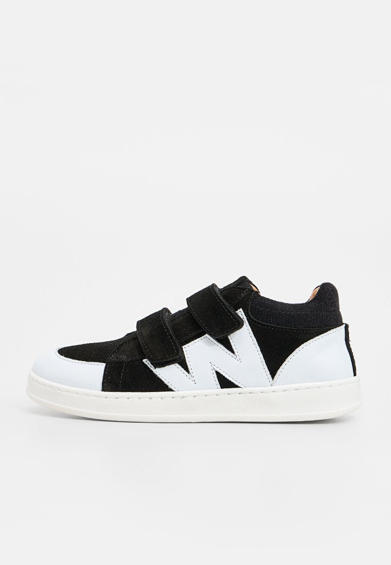 Schwarz-weiße Sneaker aus Wildleder und Leder, ausgestattet mit verstellbaren Klettverschlüssen und einer gepolsterten Sohle für zusätzlichen Komfort.