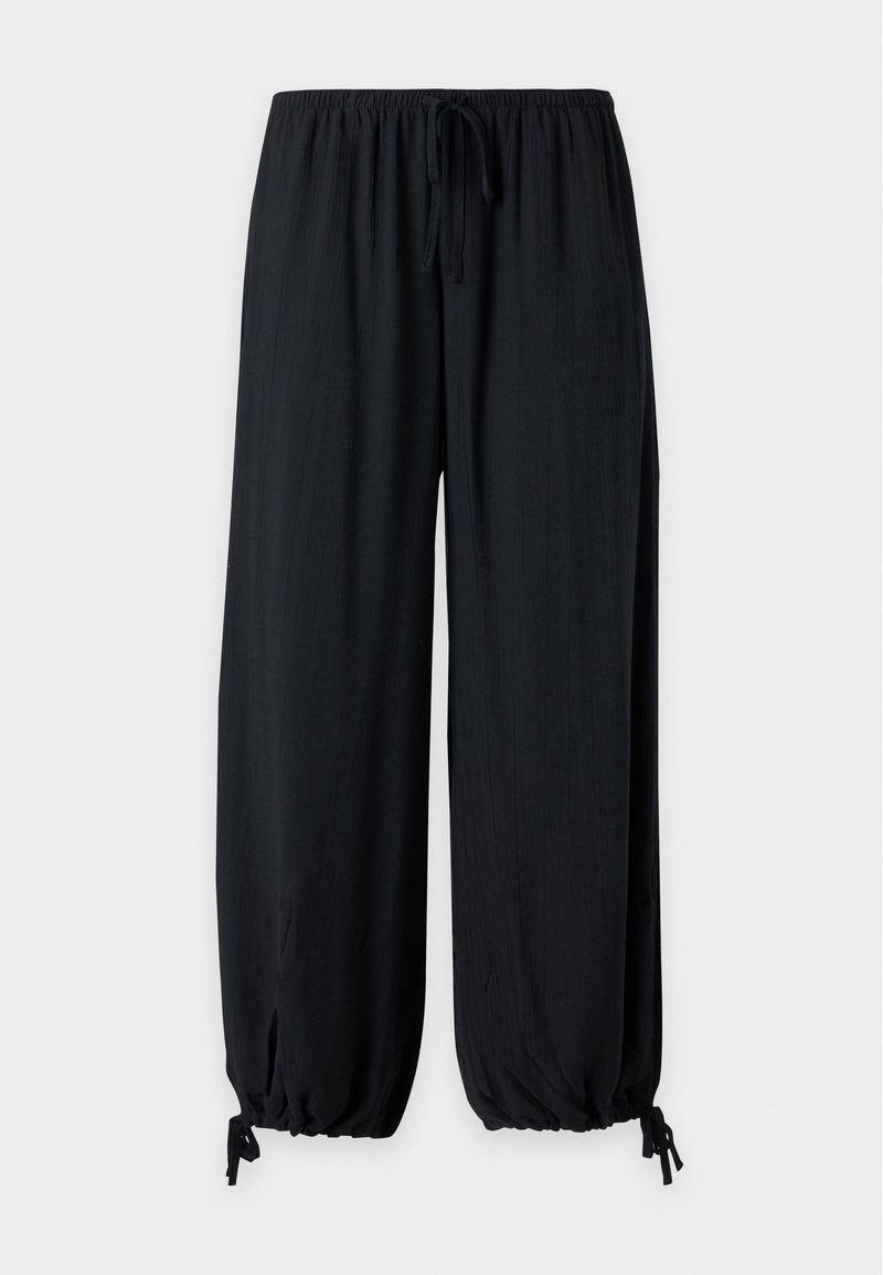 Schwarze weit geschnittene Hose mit elastischem Bund und verstellbaren Kordeln am Knöchel auf hellem, einfarbigem Hintergrund.