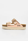 Roségoldfarbene Slip-On-Sandale mit zwei verstellbaren Schnallen, dicker beiger Sohle, Kork-Zwischensohle und "BAYTON"-Logo an der Seite.