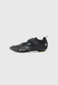 Schwarze Sportschuh mit Mesh-Obermaterial, zwei verstellbaren Klettverschlussriemen, reflektierenden Akzenten und grünen Details an der Sohle für bessere Traktion.