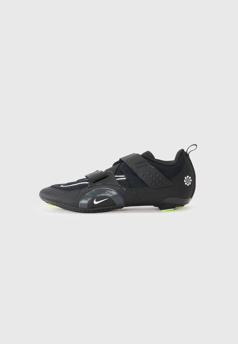 Schwarze Sportschuh mit Mesh-Obermaterial, zwei verstellbaren Klettverschlussriemen, reflektierenden Akzenten und grünen Details an der Sohle für bessere Traktion.