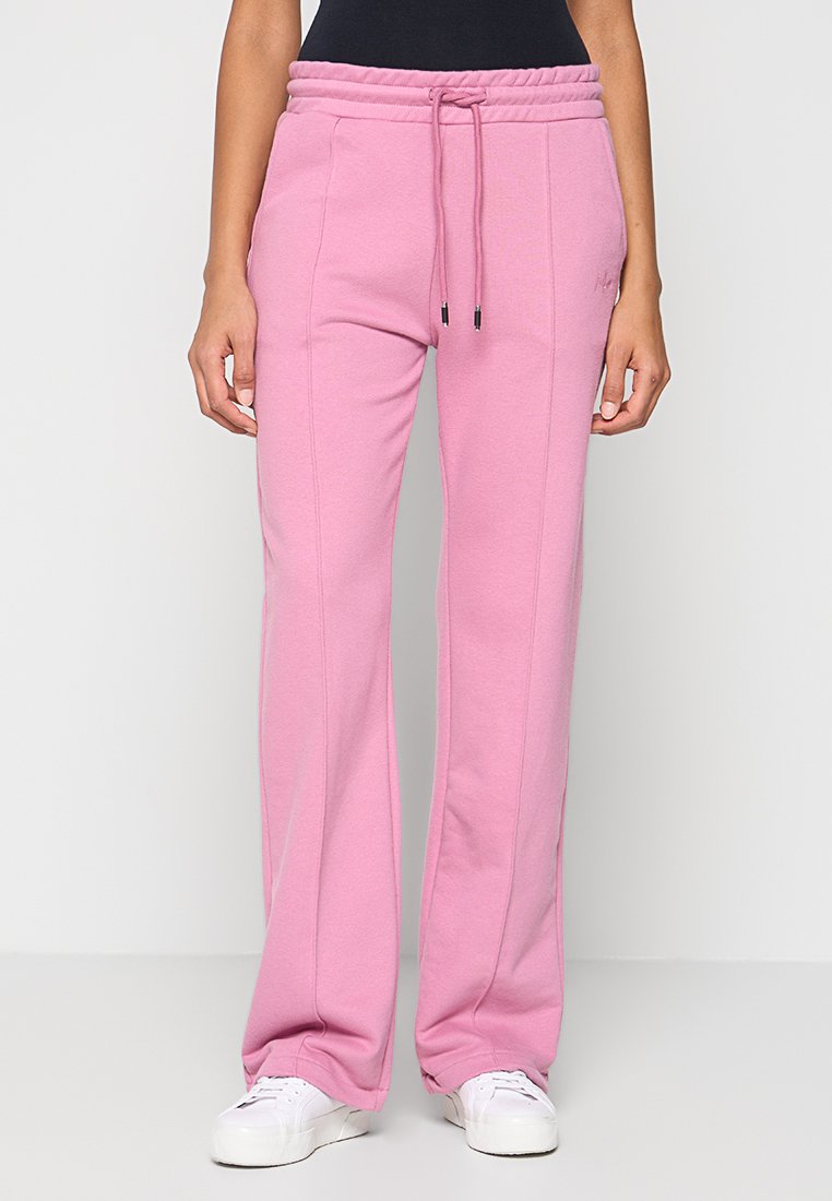 Rosa Jogginghose aus weichem Stoff, mit einem elastischen Bund und Kordelzügen, seitlichen Taschen und einem lockeren Schnitt.