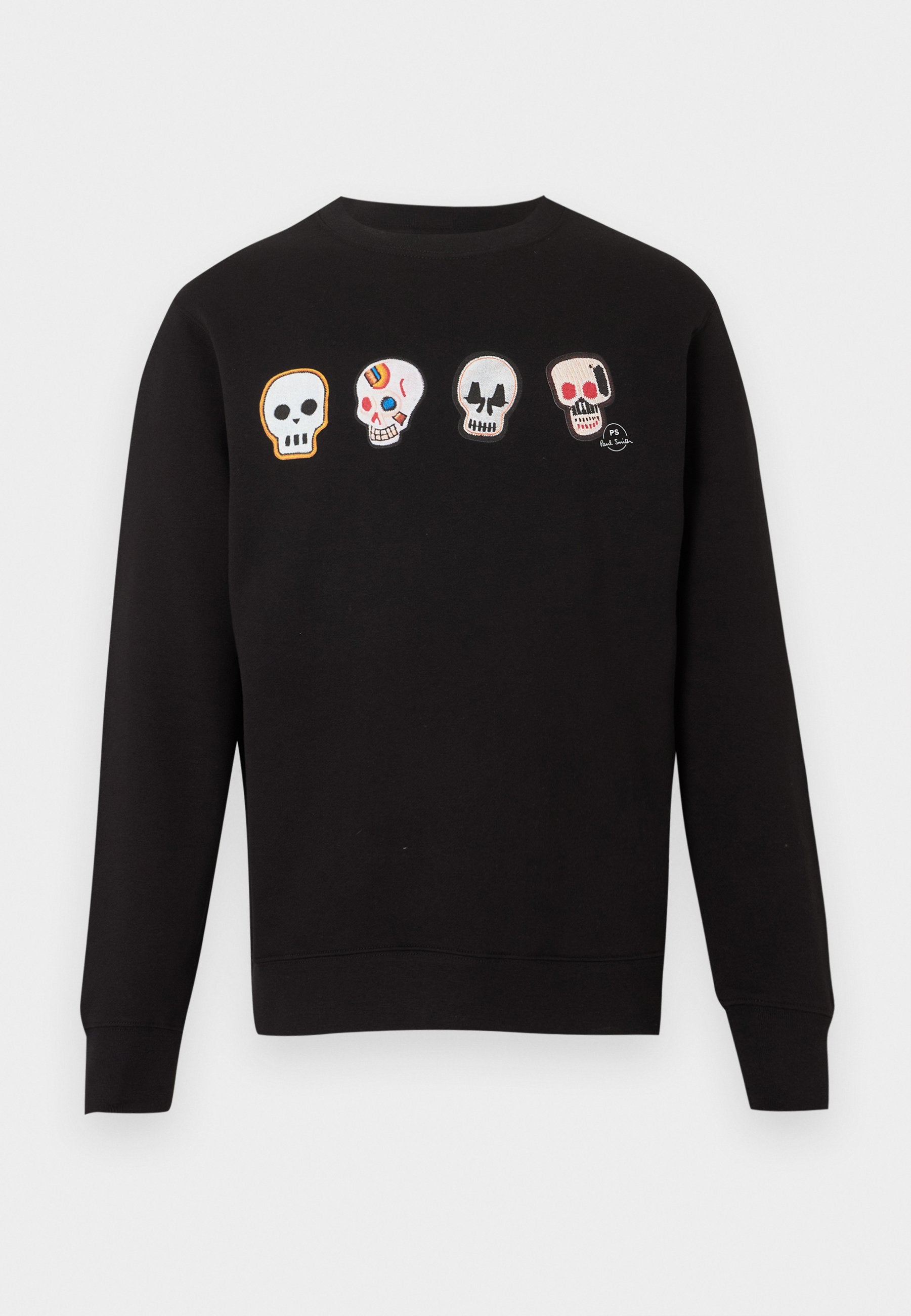 Schwarzes Langarm-Sweatshirt mit vier bestickten Schädel-Designs über der Brust, wobei jeder Schädel einzigartige Formen und bunte Details aufweist.