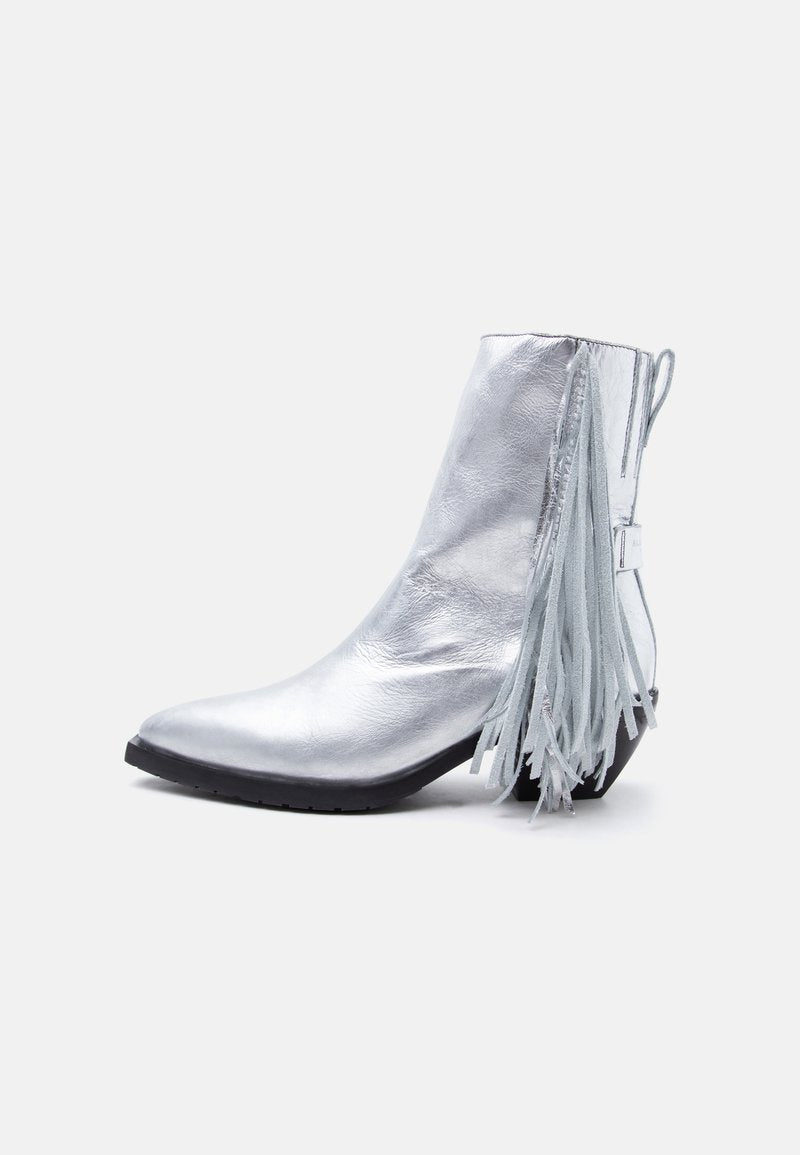 Glänzender silberner Stiefelette mit niedrigem Absatz und langen Fransen, die von der Rückseite herabhängen.