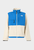 Blaue und cremefarbene Fleecejacke mit hohem Kragen, Reißverschluss vorne und Brusttasche. Verfügt über schwarze Reißverschlüsse und ein Logo auf der oberen linken Seite.