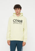 Junger Mann mit lockigem Haar, der einen hellgelben O'Neill Hoodie und blaue Jogginghosen vor einem schlichten weißen Hintergrund trägt.