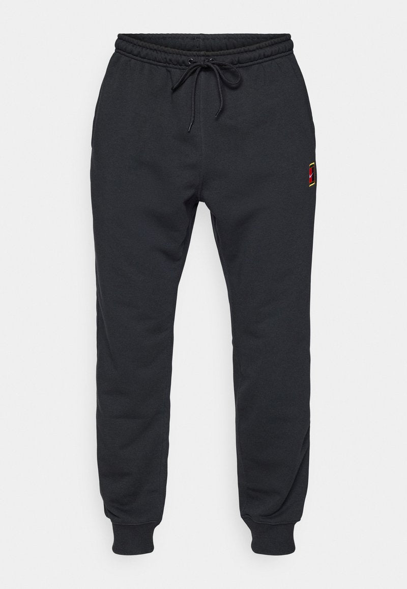 Schwarze Jogginghosen mit elastischem Bund und Knöchelbund, Kordelzug an der Taille und kleinem rot-gelben Logo an der Oberschenkeloberseite.