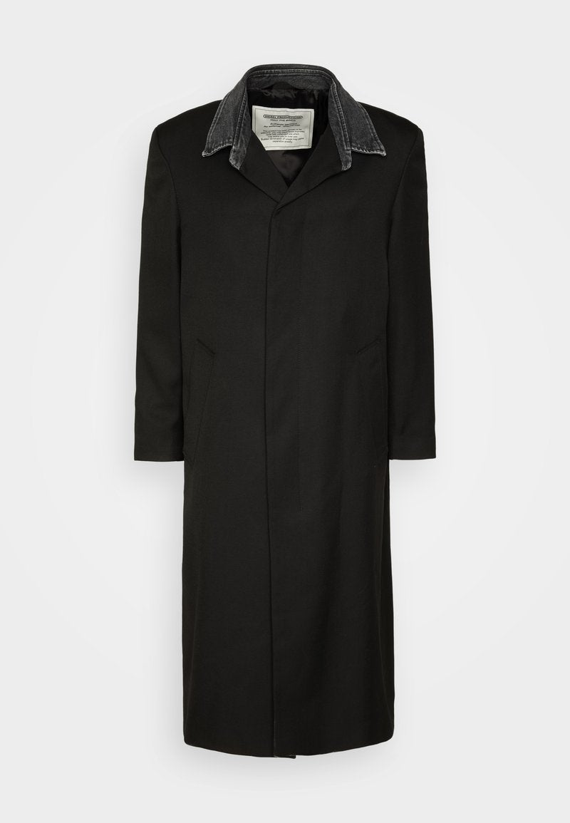 Schwarzer Mantel aus Stoff, mit einem Jeanskragen, langen Ärmeln, zwei Seitentaschen und einem geraden Schnitt mit minimalen Nähdetails.