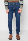 Dunkelblaue Denim-Jeans mit figurbetontem Schnitt, Fünf-Taschen-Stil und dezenten Kontrastnähten. Kombiniert mit braunen Wildleder-Stiefeletten.