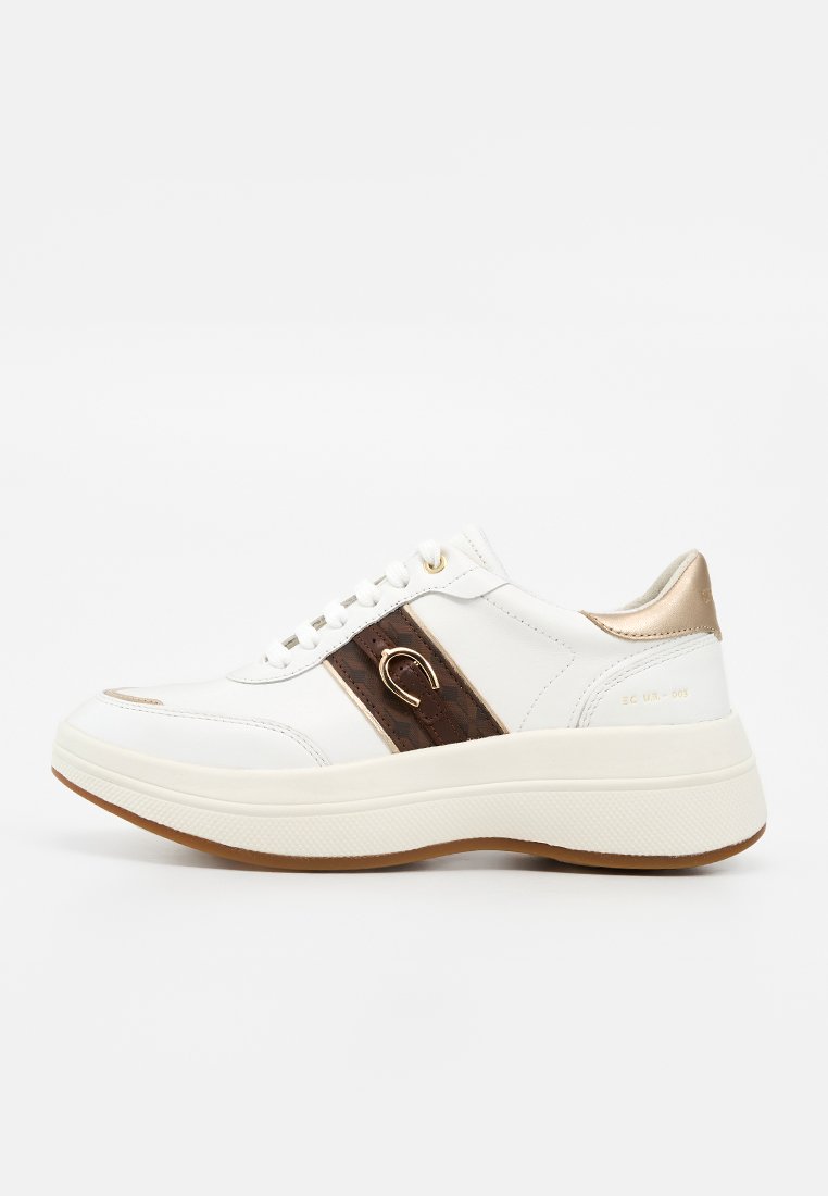 Weißer Sneaker mit dicker Sohle, brauner Lederakzent mit goldenem Hufeisendetail, goldener Fersenschlaufe und weißen Schnürsenkeln.