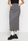 Grauer maßgeschneiderter Midirock mit hoher Taille, seitlichen Taschen und gerader Silhouette. Tragen mit schwarzen Schuhen und weißen Socken.