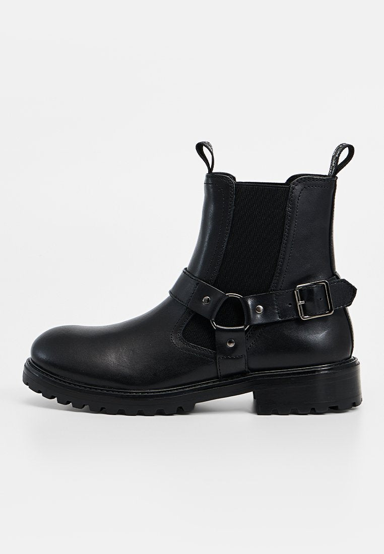 Schwarzer Lederknöchelstiefel mit elastischen Seitenteilen, einem Riemen mit Schnalle und einer robusten Sohle. Verfügt über ein glattes Finish und eine stabile Konstruktion.