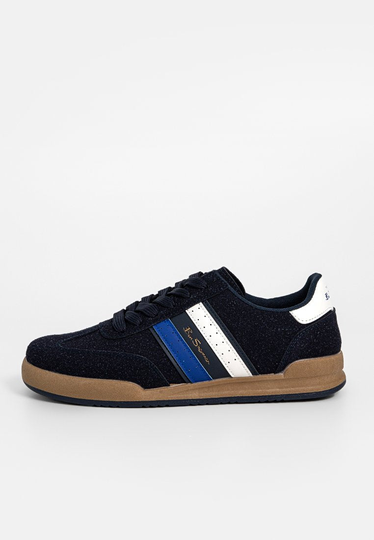 Herren Sneaker in Marineblau mit brauner Sohle, weißen und blauen seitlichen Streifen, Schnürverschluss und Markenlogo an der Seite und Ferse.