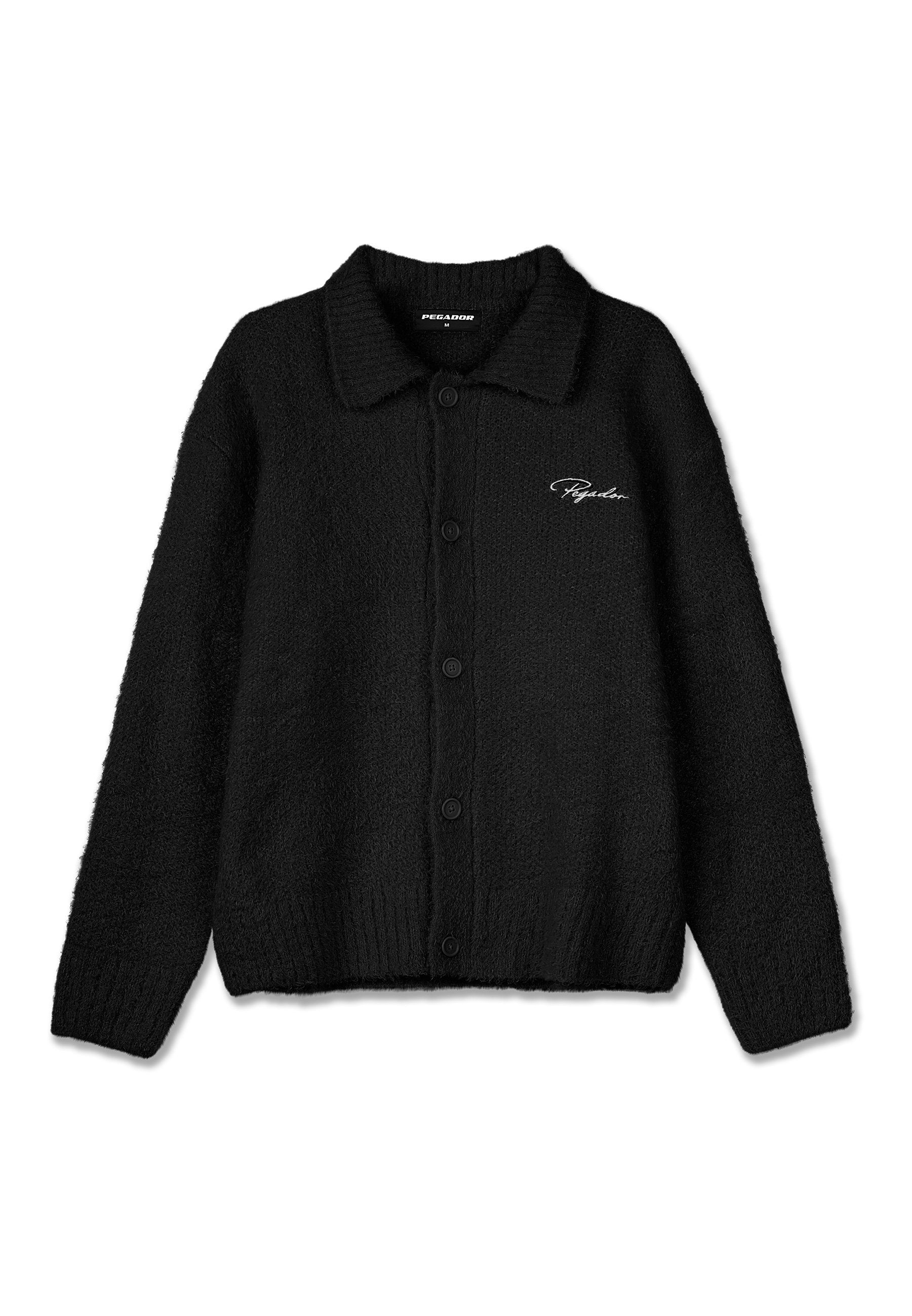 Schwarze wollene Strickjacke mit Knöpfen, Kragen, langen Ärmeln, gerippten Bündchen und Saum sowie weiß gesticktem "Pegador"-Logo auf der Brust.