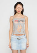 Graues Tanktop mit Ausschnitten und einem aufgedruckten "DIESEL"-Logo. Kombiniert mit einem hellblauen Jeans-Minirock mit einer runden Schnalle.