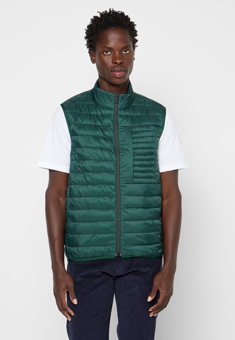 Grüne Steppweste mit horizontalem Quilt-Design, hohem Kragen, Reißverschluss vorne und linker Brusttasche, kombiniert mit einem weißen Hemd.