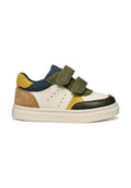 Bunt gefärbter Sneaker mit einer weißen Lederbasis, grünen und gelben Wildlederakzenten, navyblauem Textil und doppelten Velcro-Riemen zum Verschließen.