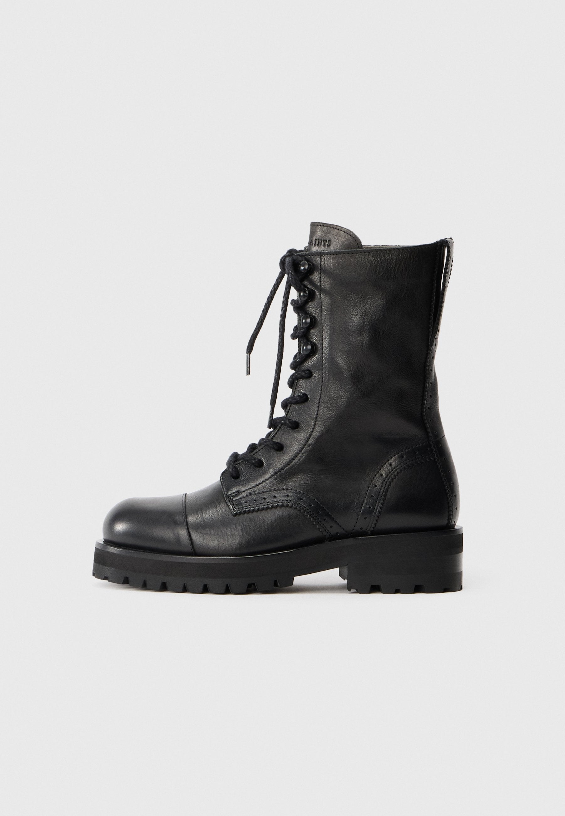 Schwarze Leder Schnürstiefel mit runder Zehenpartie, Broguemuster und robuster Gummisohle. Verfügt über einen Reißverschluss auf der Rückseite für ein einfaches An- und Ausziehen.