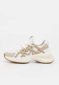 Weißer und beiger Sneaker mit dicker Sohle, verziert mit kleinen goldenen Nieten und Strasssteinen, von der rechten Seite auf einfarbigem Hintergrund gezeigt.