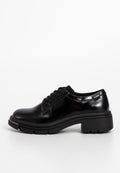 Schwarze Leder Schnürschuhe mit runder Zehenpartie, strukturiertem Obermaterial und robuster Gummisohle. Mit subtiler Markenkennzeichnung an der Seite.