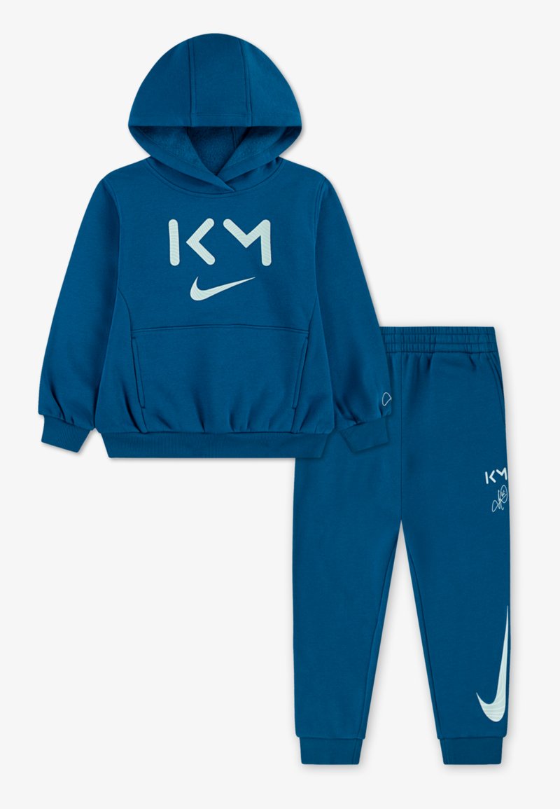 Blauer Baumwollhoodie mit einer Kängurutasche, mit hellblauem Text "KM" und einem Nike-Logo. Passende blaue Hose mit elastischem Bund und Logo.