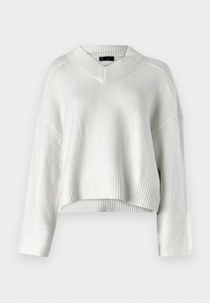 Weißer, gekürzter Pullover mit V-Ausschnitt, geripptem Saum und langen Ärmeln. Hergestellt aus einem weichen, strukturierten Strickmaterial. Einfaches und vielseitiges Design.