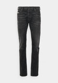 Schwarze Denim-Jeans mit geradem Schnitt, versehen mit Abnutzungsspuren am Knie, Fünf-Taschen-Design und subtiler Ausbleichung der Stoffstruktur.