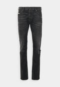Schwarze Denim-Jeans mit geradem Schnitt, versehen mit Abnutzungsspuren am Knie, Fünf-Taschen-Design und subtiler Ausbleichung der Stoffstruktur.