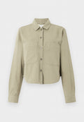 Beige kurze Jacke mit langen Ärmeln, Kragen, Knöpfen vorne und zwei großen Brusttaschen vor einfachem Hintergrund.