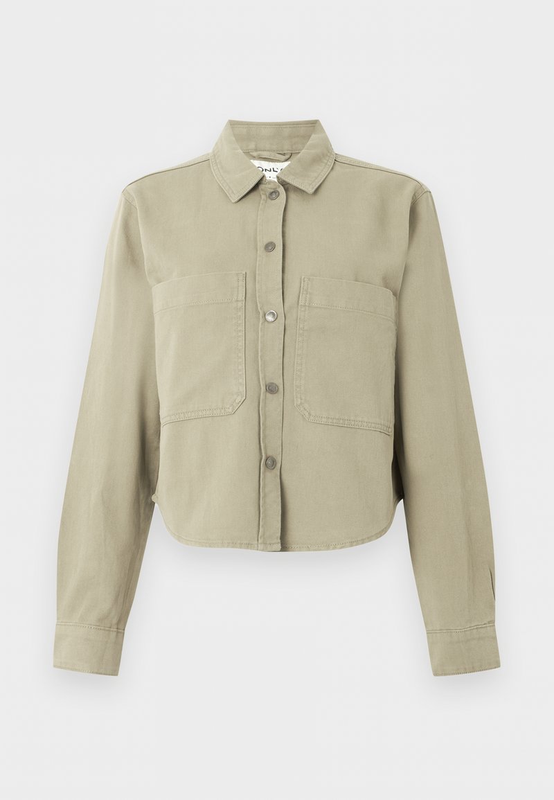 Beige kurze Jacke mit langen Ärmeln, Kragen, Knöpfen vorne und zwei großen Brusttaschen vor einfachem Hintergrund.