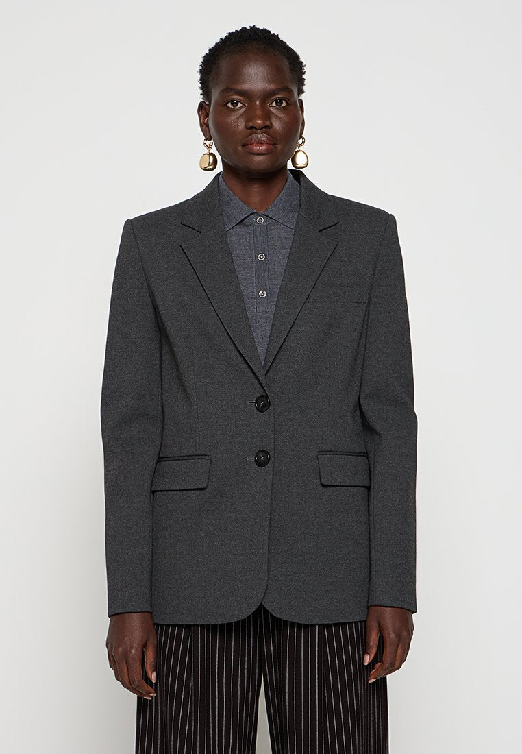 Grauer Blazer aus strukturiertem Wollmix, einreihig mit zwei Knöpfen, mit Reverskragen und zwei Fronttaschen. Kombiniert mit einem Hemd mit Kragen.