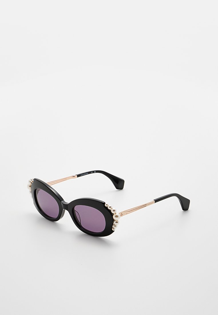 Schwarze Sonnenbrille mit ovalen lila Gläsern, verziert mit Perlenakzenten entlang der oberen Kante und goldfarbenen Metallbügeln mit strukturierten Details.