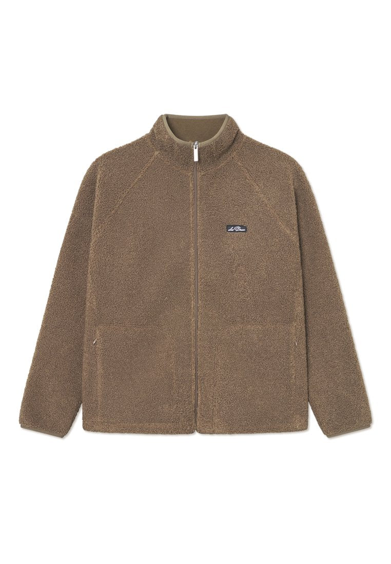 Braune Fleecejacke mit hohem Kragen, Reißverschluss vorne und zwei Fronttaschen. Strukturierte Oberfläche mit zusätzlichem Branding-Detail auf der Brust.