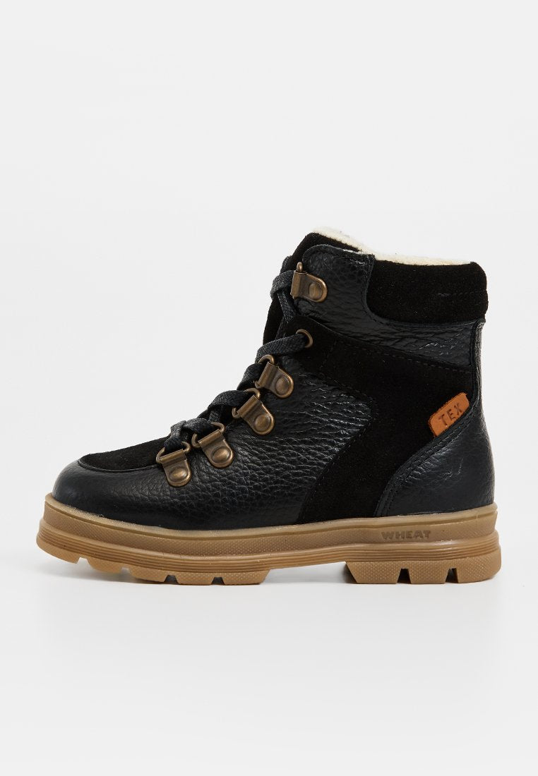 Schwarzer wasserdichter Stiefel aus strukturiertem Leder und Wildleder, mit Metallhaken, einer braunen Gummisohle und einem weichen Futter am Kragen.