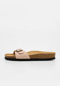 Beige Wildleder-Slidesandale mit einem verstellbaren Riemen, Kork-Fußbett und schwarzer strukturierter Sohle, von der Seite auf weißem Hintergrund gezeigt.