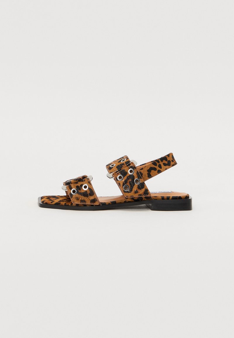Flache Sandalen mit Leopardenmuster, zwei breiten Riemen, Metallösen und einem flachen Absatz. Hergestellt aus synthetischem Material mit glatter Textur.