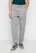 Graue Cargo-Hosen mit elastischem Bund, Seitentaschen und Cargo-Taschen, schmal zulaufendem Schnitt und Knöchelbündchen. Hergestellt aus leichtem Stoff.