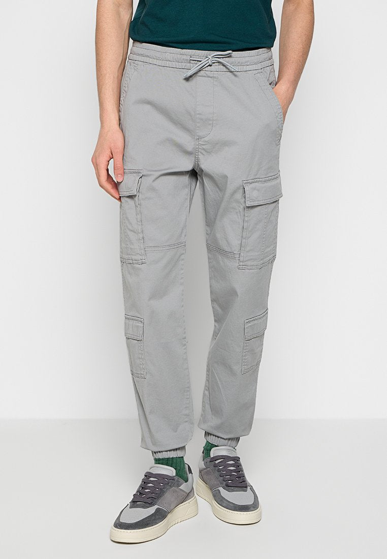 Graue Cargo-Hosen mit elastischem Bund, Seitentaschen und Cargo-Taschen, schmal zulaufendem Schnitt und Knöchelbündchen. Hergestellt aus leichtem Stoff.
