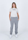 Graues T-Shirt mit kurzen Ärmeln und schwarzem "Hurley"-Logo, kombiniert mit grauen Sweatpants mit strukturiertem Bund und seitlichen Taschen. Weiße Sneaker.
