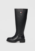 Schwarze knielange Stiefel aus glattem Leder mit einer strukturierten Gummisohle, versehen mit einem kleinen Logoschild in Rot, Weiß und Blau.