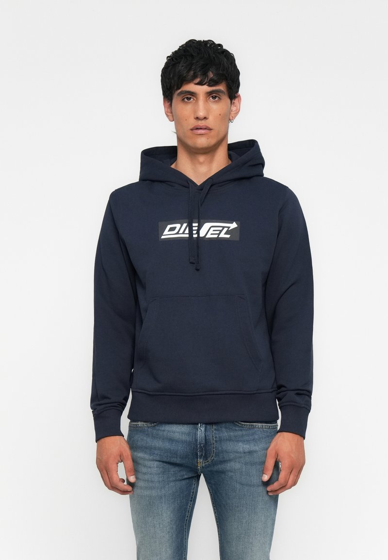 Marineblauer Hoodie aus Baumwollmischung, mit Kängurutasche und weißem "DIESEL"-Logo auf einem schwarzen rechteckigen Patch. Weiche Textur.