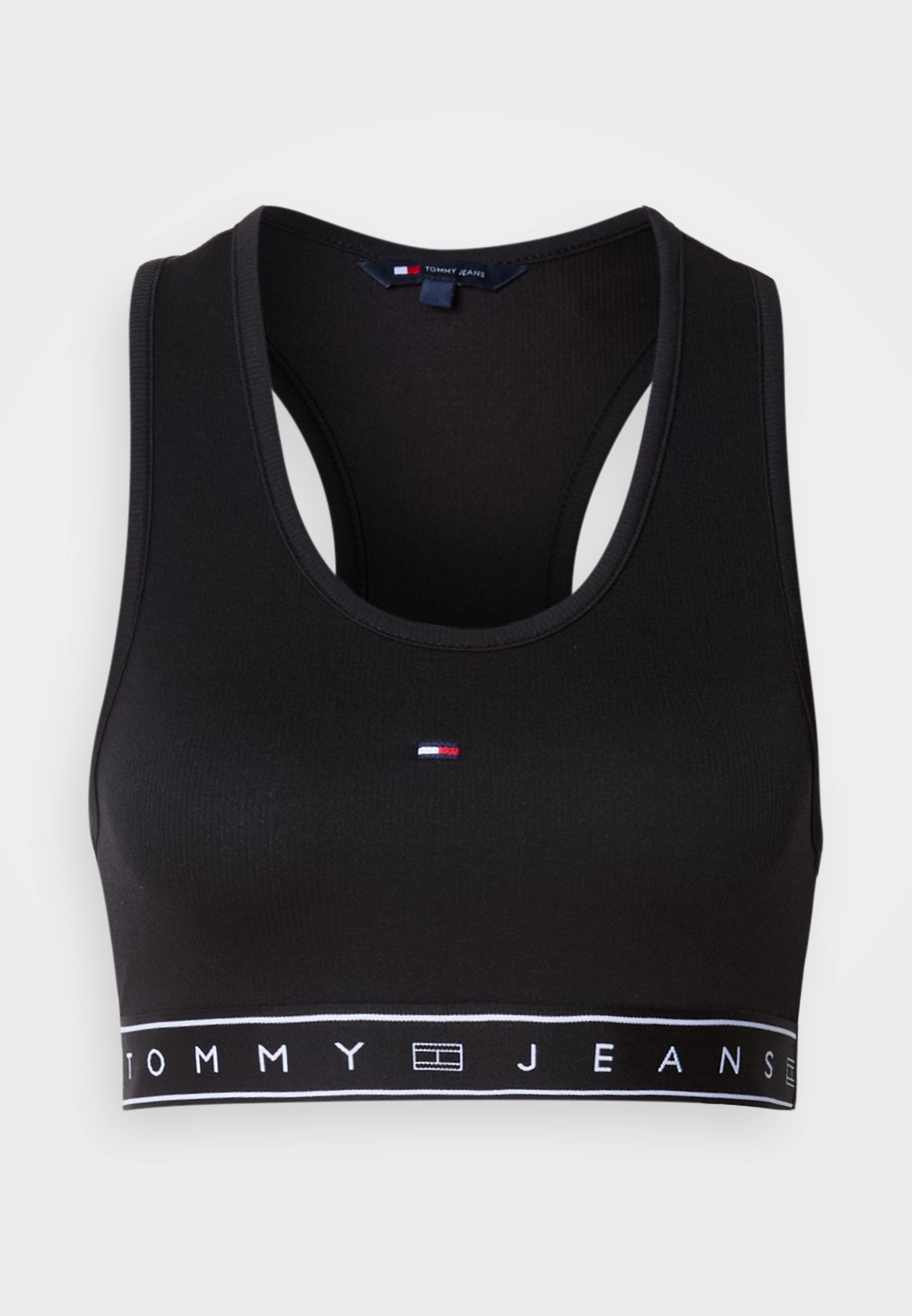 Schwarzes Crop-Top-Sport-BH aus glattem Stoff. Mit Racerback-Design und weißem Band mit "TOMMY JEANS"-Logo. Kleines Logo vorne.