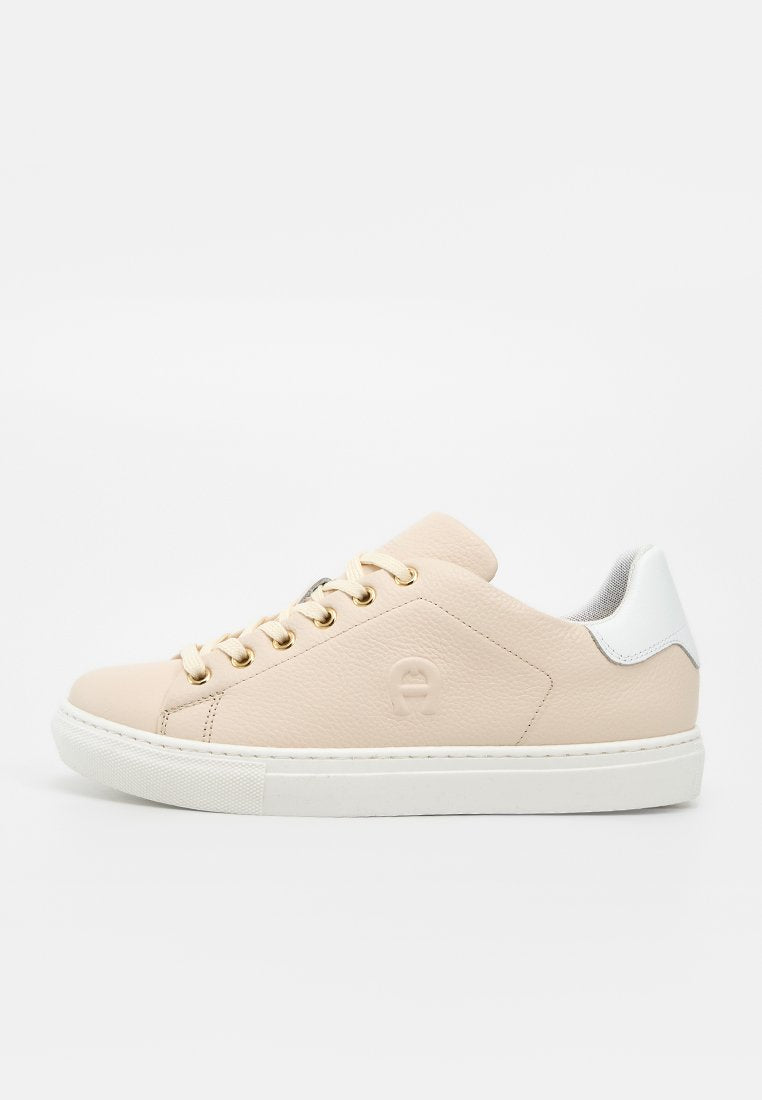 Beiger Leder-Sneaker mit niedrigem Schnitt, weißer Gummisohle, goldenen Ösen, beigen Schnürsenkeln und weißem Absatzakzent mit seitlich eingeprägtem Logo.