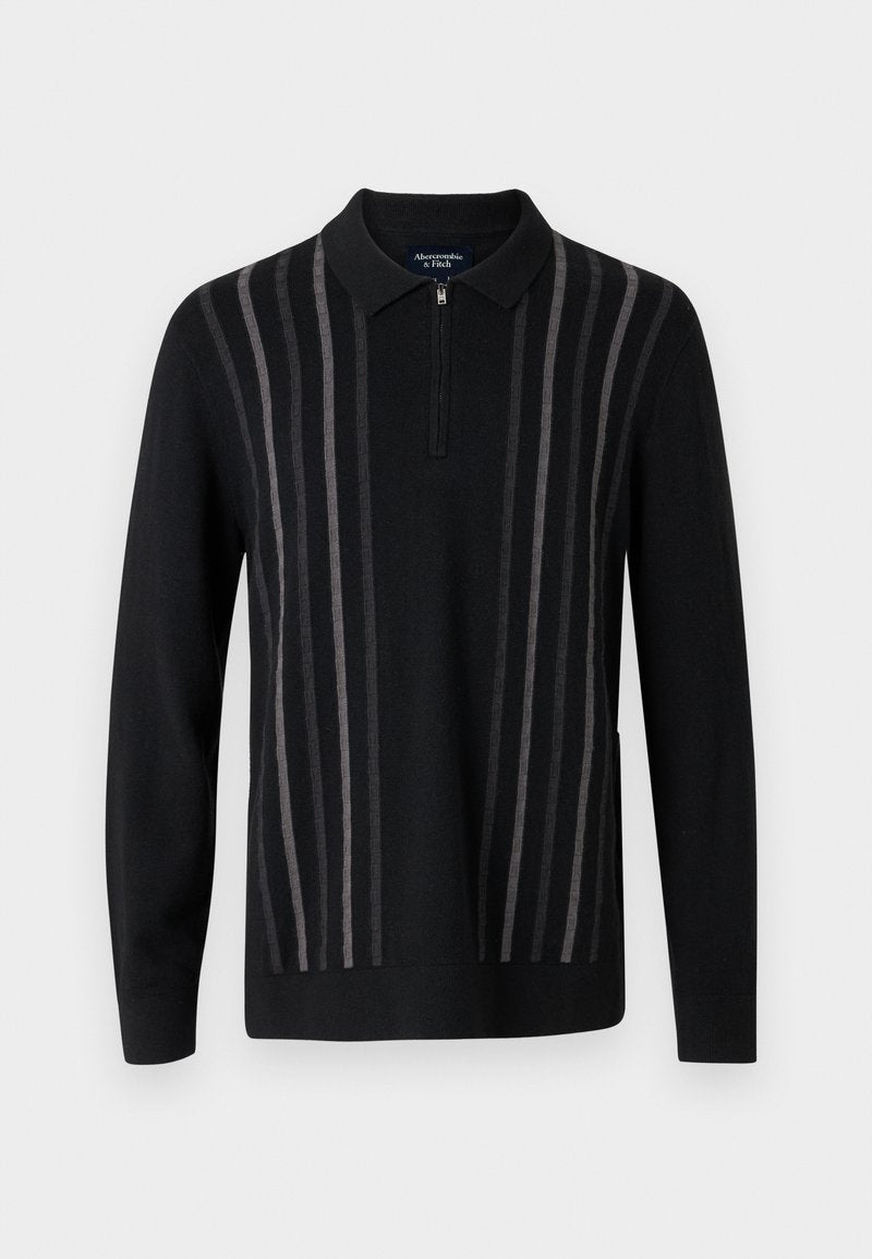 Schwarzer Pullover mit Reißverschlusskragen, mit vertikalen grauen Streifen, aus weichem Strickstoff, mit langen Ärmeln und seitlichen Schlitzen.